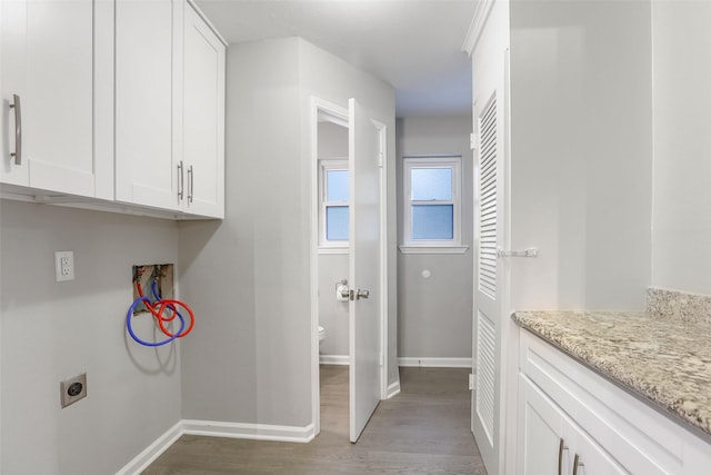 clothes washing area with hookup for a washing machine, wood finished floors, hookup for an electric dryer, cabinet space, and baseboards