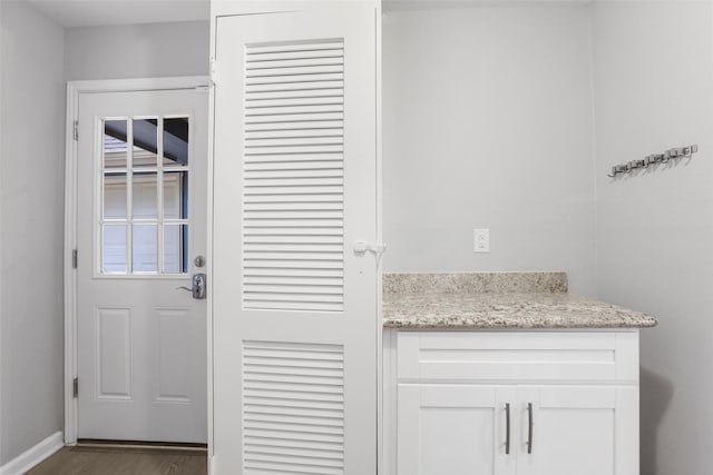 doorway featuring baseboards and wood finished floors