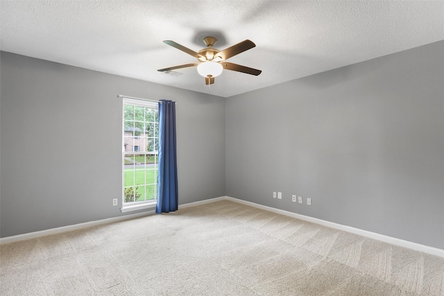 empty room with baseboards, light colored carpet, a textured ceiling, and ceiling fan