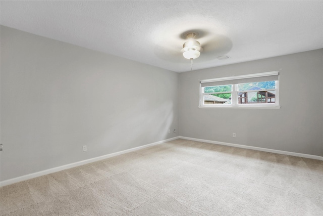 empty room with baseboards, a ceiling fan, and light colored carpet