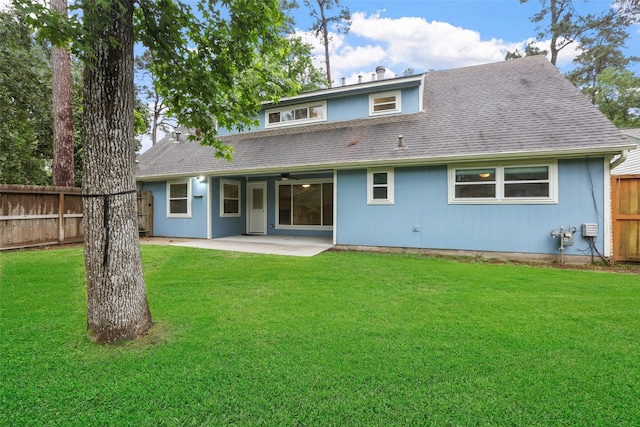 rear view of house featuring a yard, roof with shingles, fence, and a patio area