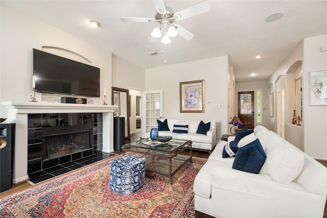 living room with recessed lighting, wood finished floors, visible vents, a ceiling fan, and a tiled fireplace