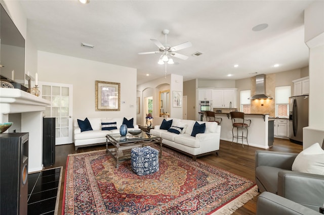 living room featuring arched walkways, visible vents, a ceiling fan, and recessed lighting
