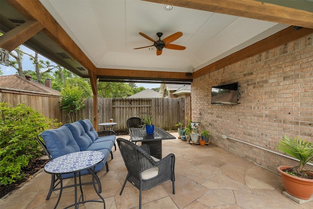 view of patio / terrace with a ceiling fan, fence, and an outdoor living space