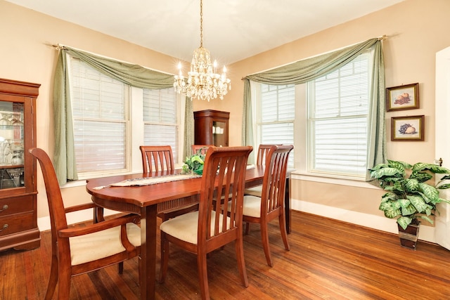 dining space featuring baseboards, wood finished floors, and a chandelier