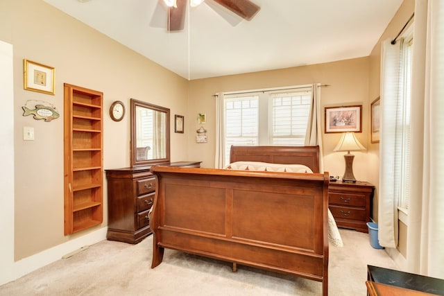 bedroom featuring a ceiling fan, baseboards, and light carpet