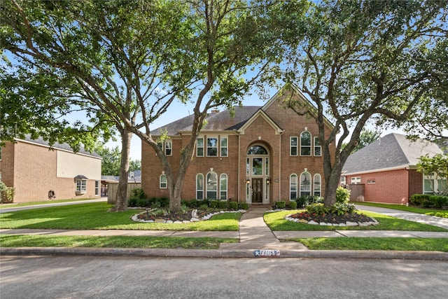 view of front of property featuring a front lawn and brick siding