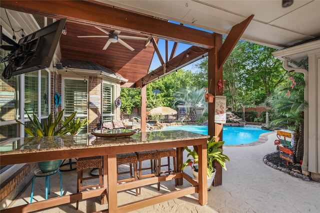 view of patio featuring ceiling fan and an outdoor pool