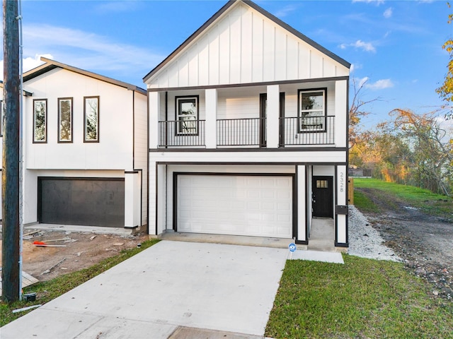 view of front of home featuring board and batten siding, concrete driveway, a balcony, and a garage