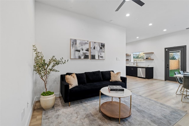 living area with recessed lighting, light wood-style flooring, a ceiling fan, and baseboards