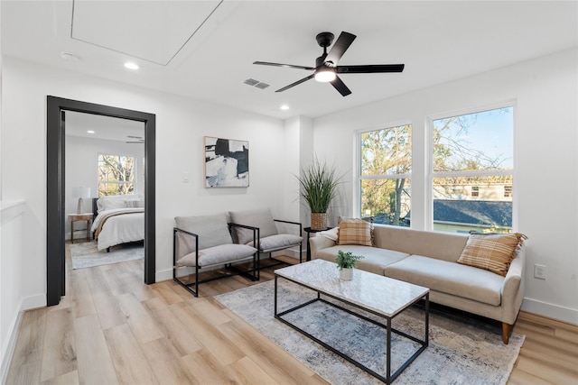 living room featuring attic access, light wood finished floors, visible vents, and recessed lighting