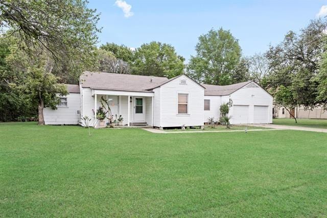 view of front of home with an attached garage, driveway, and a front yard