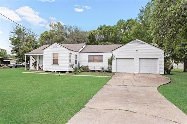 view of front of property with an attached garage, a front lawn, and concrete driveway