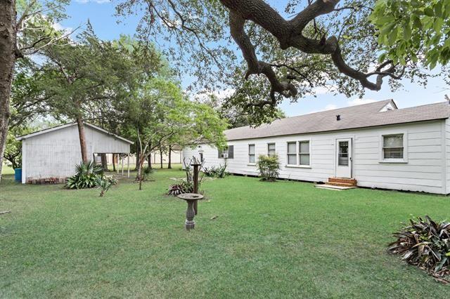 rear view of property featuring a yard and entry steps