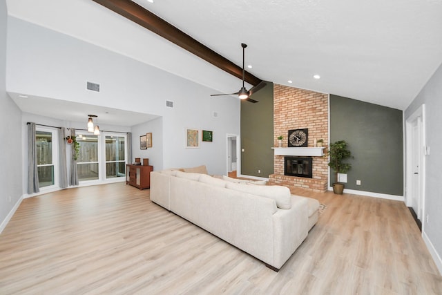 living room with visible vents, a fireplace, light wood-type flooring, baseboards, and beamed ceiling
