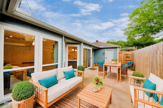 view of patio featuring outdoor dining area, fence, and an outdoor hangout area