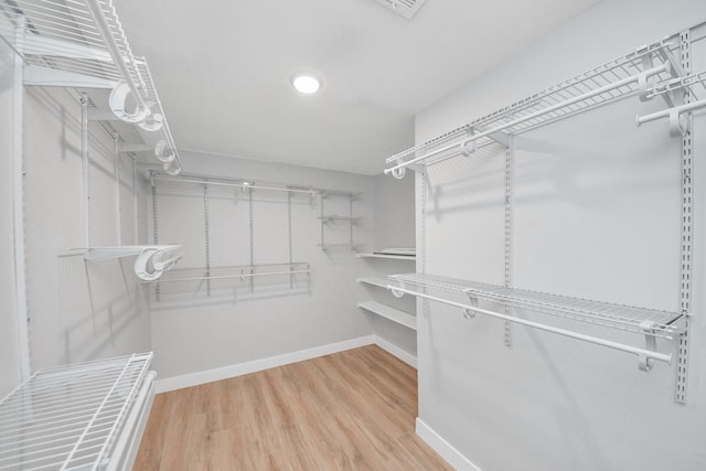 spacious closet featuring wood finished floors and radiator