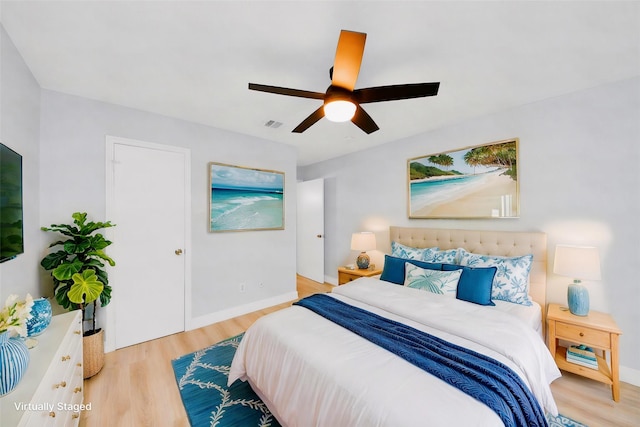 bedroom with a ceiling fan, baseboards, visible vents, and light wood-style floors