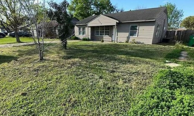 bungalow-style home featuring a front lawn and fence