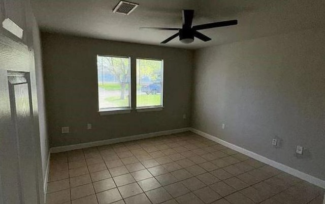 tiled spare room with baseboards, a ceiling fan, and visible vents