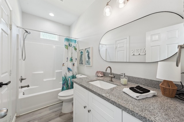 bathroom with shower / bath combination with curtain, wood finished floors, vanity, and toilet