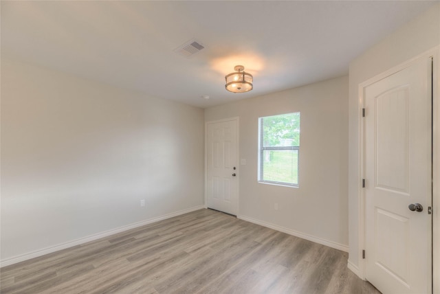 unfurnished bedroom featuring baseboards, visible vents, and light wood-style flooring