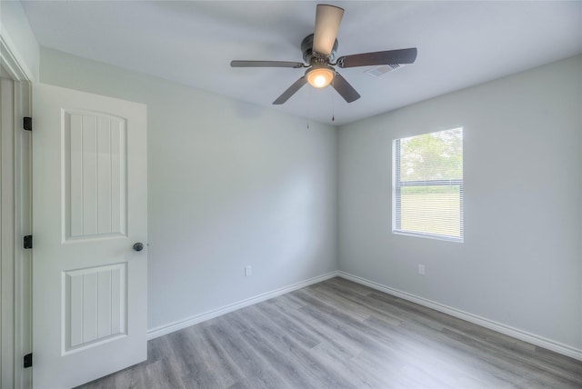 spare room with wood finished floors, baseboards, and ceiling fan