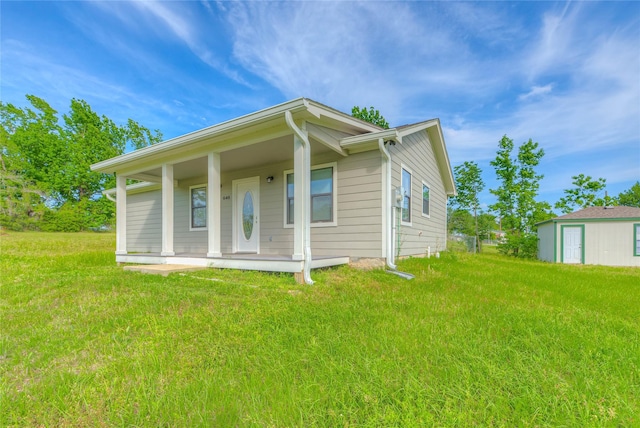 back of property featuring covered porch and a yard