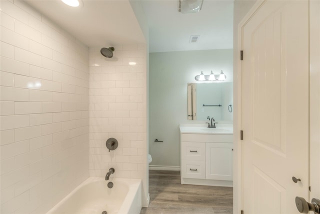 full bath with wood finished floors, toilet, vanity, visible vents, and tub / shower combination