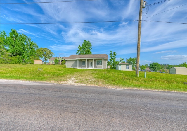 bungalow with driveway, a storage shed, and an outbuilding