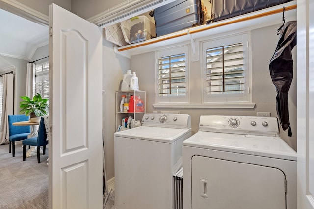 washroom featuring light colored carpet, ornamental molding, washer and dryer, and laundry area