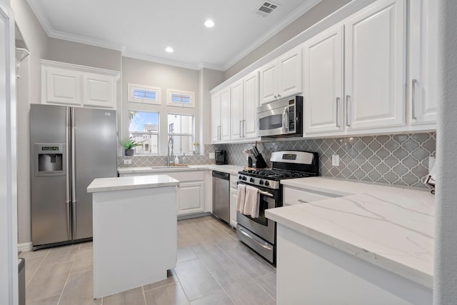 kitchen with backsplash, visible vents, a sink, ornamental molding, and stainless steel appliances