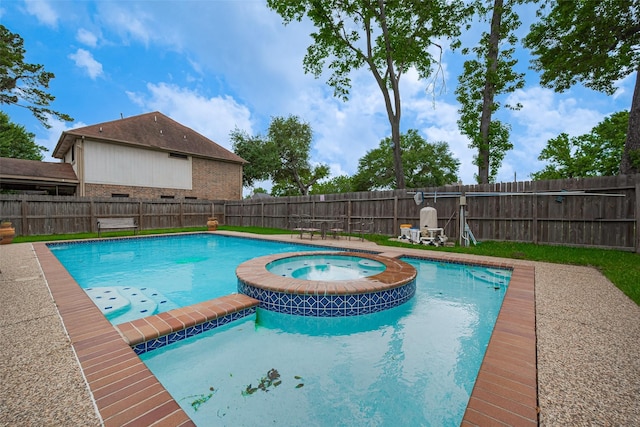 view of swimming pool featuring a pool with connected hot tub and a fenced backyard