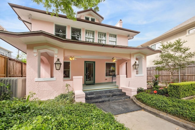 traditional style home featuring fence, a chimney, ceiling fan, and stucco siding