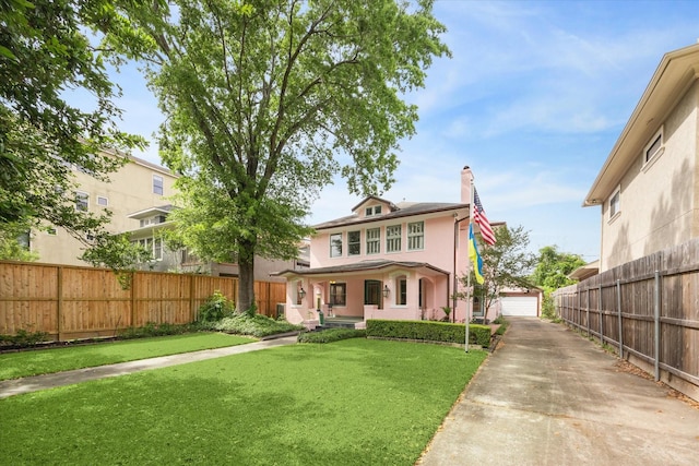 rear view of house with a chimney, a porch, stucco siding, fence, and a lawn
