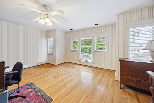office featuring ceiling fan, light wood finished floors, and baseboards