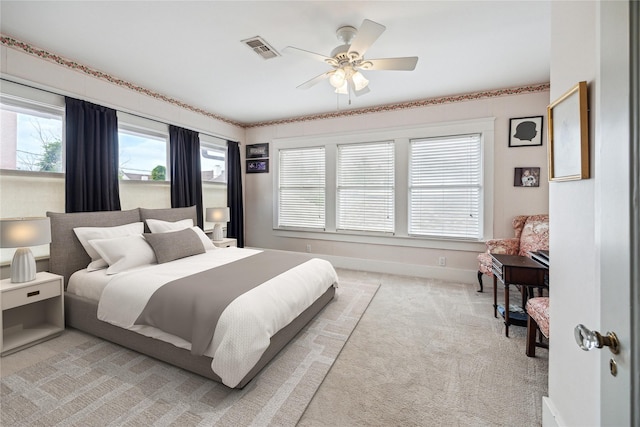 bedroom with light colored carpet, visible vents, a ceiling fan, and baseboards