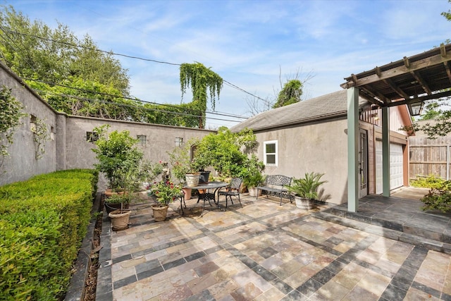 view of patio / terrace with fence, a pergola, and an attached garage