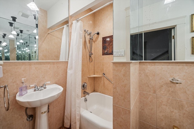 bathroom with shower / bath combo and tile walls