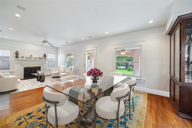 dining space with light wood finished floors, ceiling fan, baseboards, and a healthy amount of sunlight