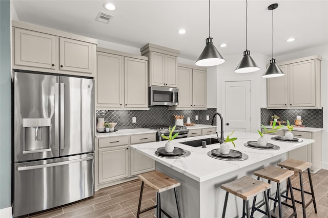 154 W Coralburst Loop, Montgomery, TX 77316 - kitchen with a sink, wood tiled floor, a breakfast bar area, and appliances with stainless steel finishes