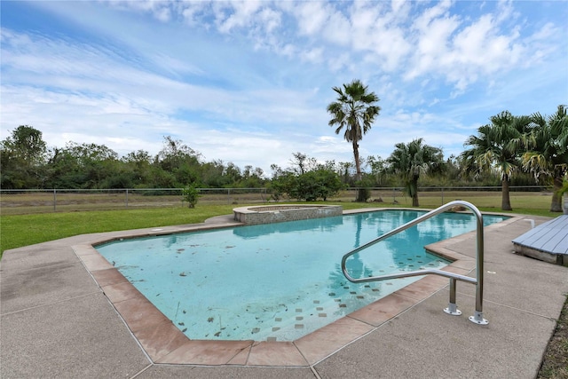 view of pool featuring a yard, a pool with connected hot tub, and fence