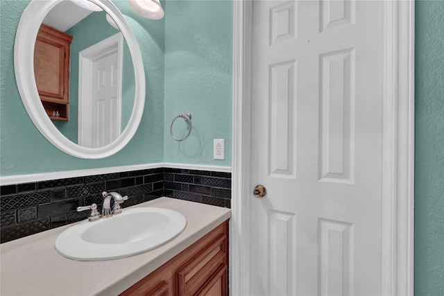 bathroom featuring a textured wall and vanity