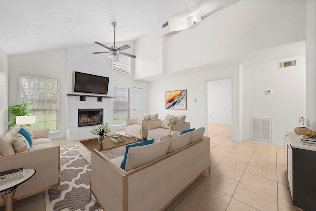 living area with ceiling fan, a brick fireplace, and visible vents