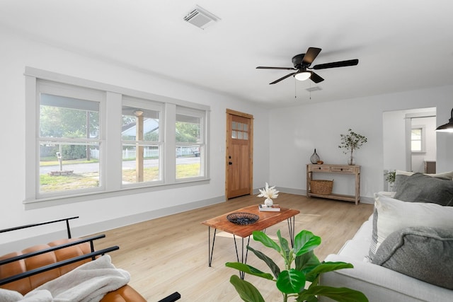living area with light wood-style floors, visible vents, a ceiling fan, and a wealth of natural light