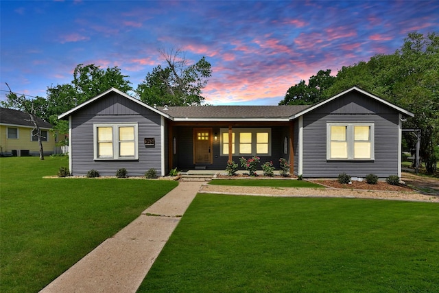ranch-style house with a porch and a lawn