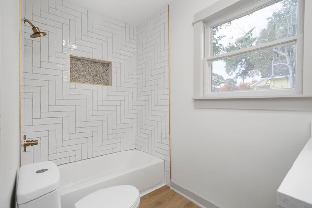 full bathroom with wood finished floors, toilet, baseboards, and shower / washtub combination