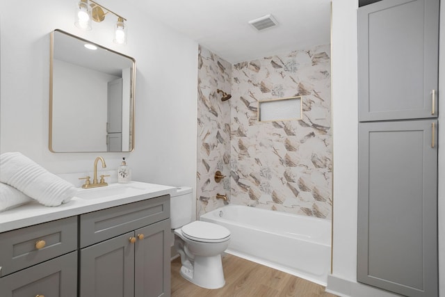 bathroom with shower / washtub combination, wood finished floors, visible vents, toilet, and vanity