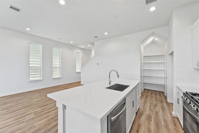 kitchen with a sink, light wood-type flooring, visible vents, light countertops, and appliances with stainless steel finishes