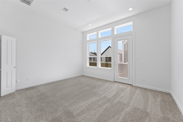 unfurnished room featuring baseboards, visible vents, and carpet